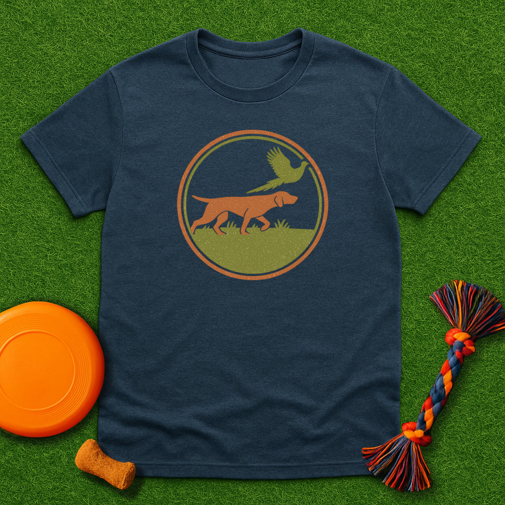 heather blue t-shirt with a dog and bird graphic on a grass background with a frisbee and dog toy.