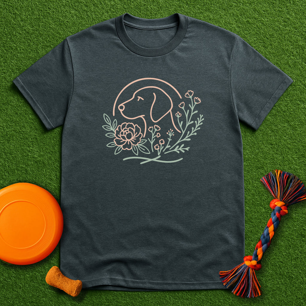Dark gray t-shirt with dog and floral design on a green surface with toys.