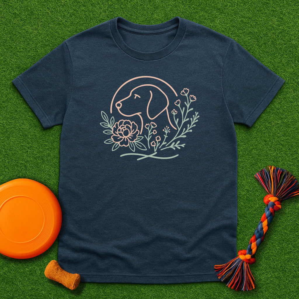 Navy blue t-shirt with a dog and floral design on a green surface with a frisbee and dog toy.