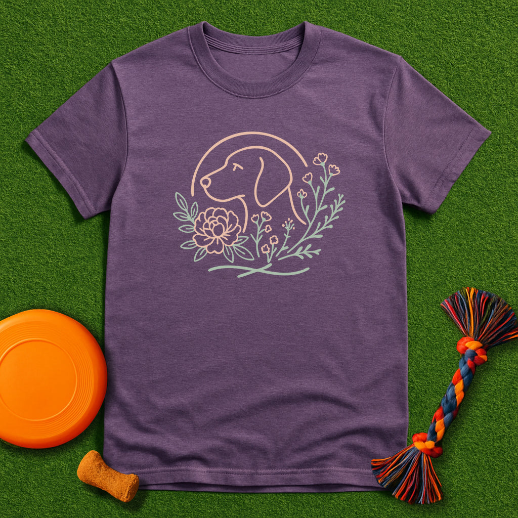 Purple t-shirt with dog graphic on a green surface with dog toys.
