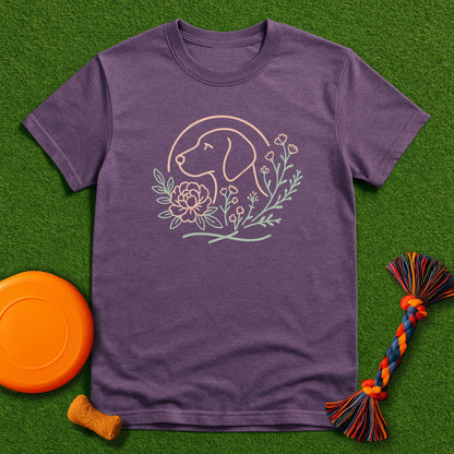 Purple t-shirt with dog graphic on a green surface with dog toys.
